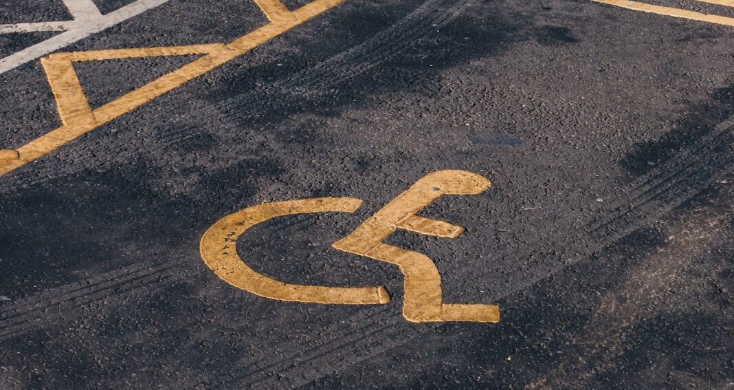Wheelchair symbol painted on a road to illustrate reasonable accommodation
